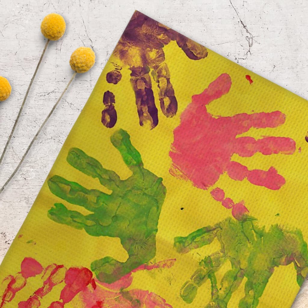 Colorful handprints on a hanging tea towel