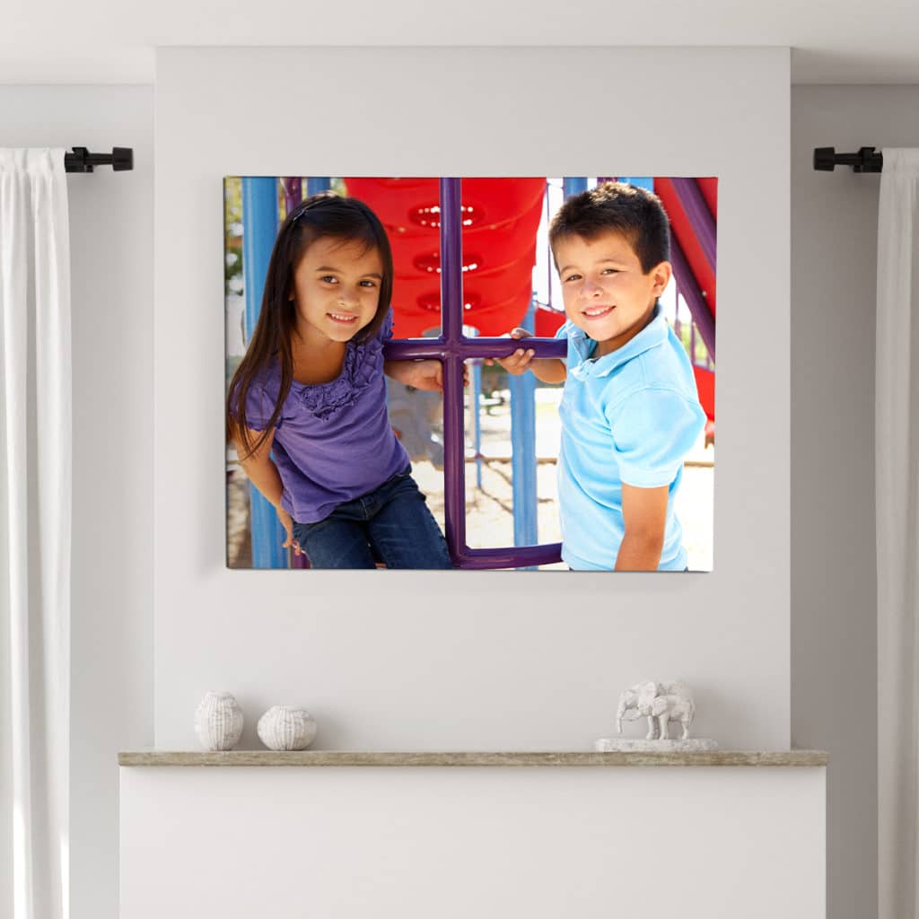 Large size canvas print with a photo of two kids hanging on the wall 