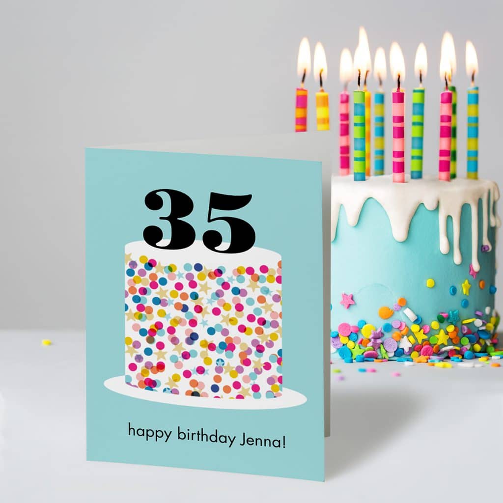 Sprinkle Cake birthday greeting card standing next to a beautiful blue sprinkled cake with candles