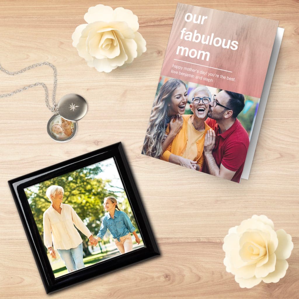Mother's Day card laying on a table next to a keepsake box and photo locket, all featuring special Mother's Day photos
