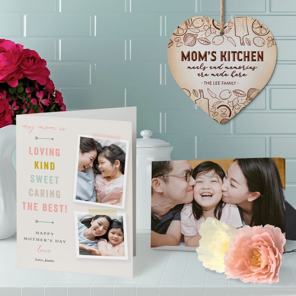 Mother's Day card and tabletop canvas print sitting on a kitchen counter with a stone heart trivet hanging in the background