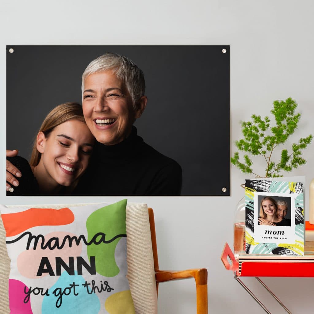 Acrylic print photo of mom and daughter hanging on the wall behind a custom Mom pillow and card