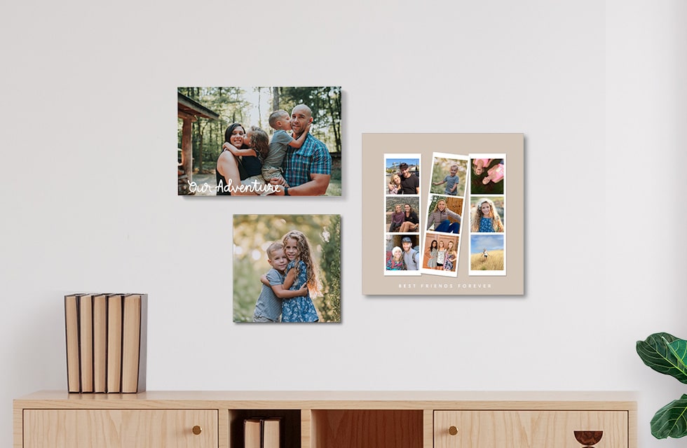 Three photo tiles in three different sizes hanging on a wall over a credenza