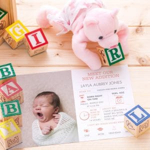 Baby girl birth announcement surrounded by toy blocks reading "BABY GIRL"