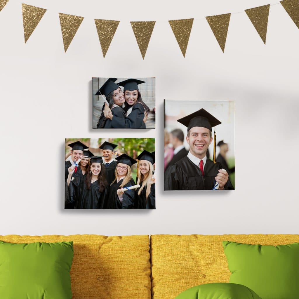 Three canvas prints featuring photos of smiling graduates hanging on a wall over a yellow couch
