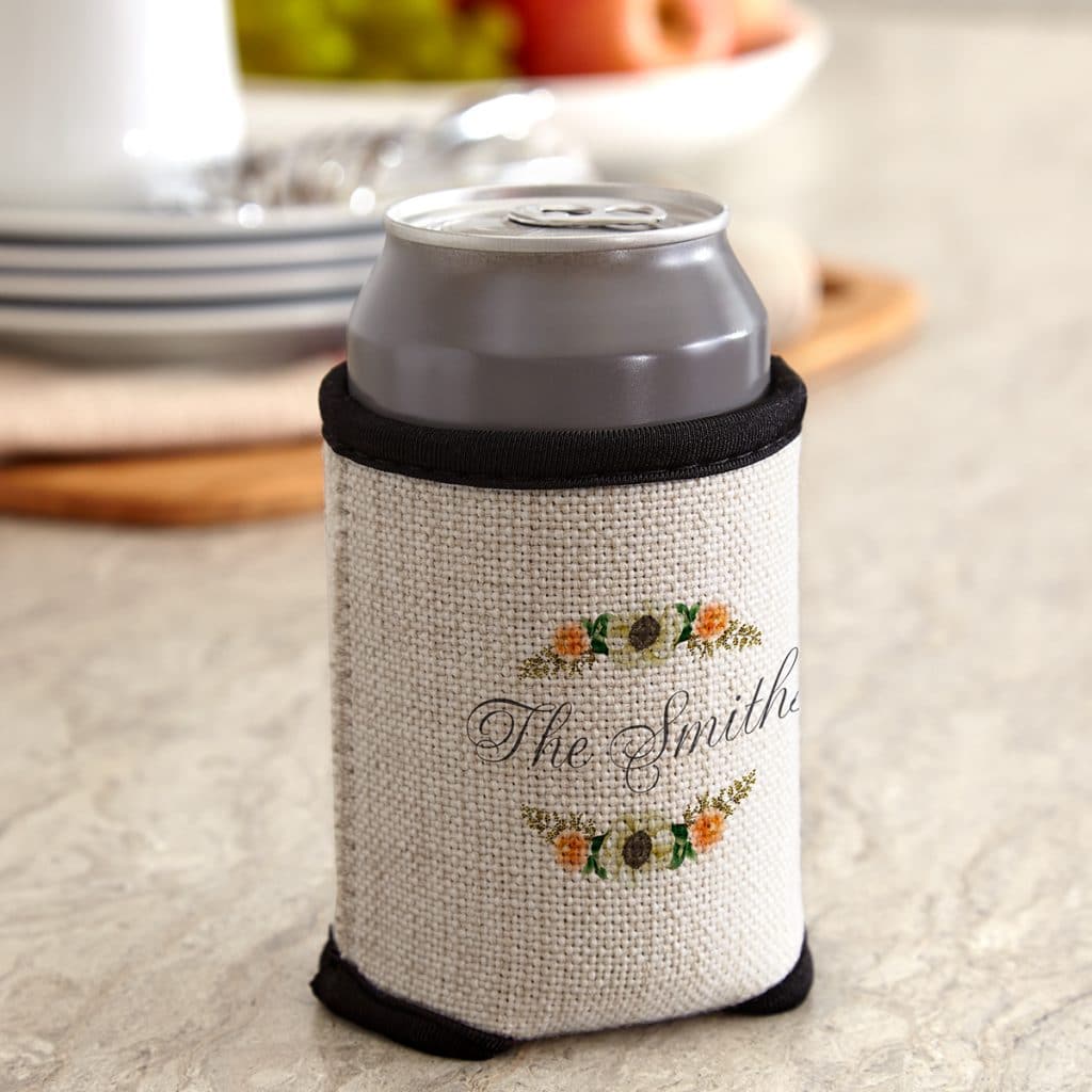 Floral Frame cloth can cooler holding a can, sitting on a kitchen counter