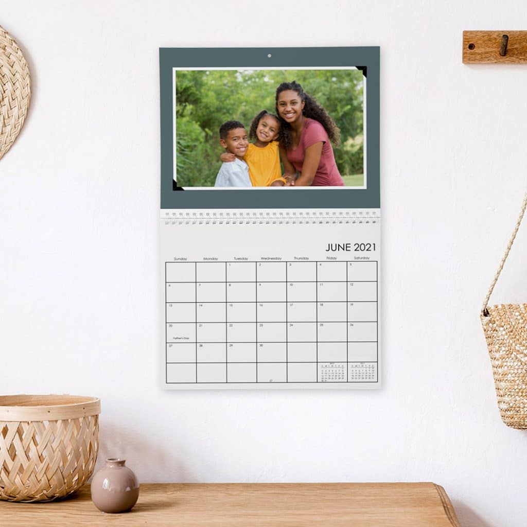 Image of a photo wall calendar hanging on a wall over a desk