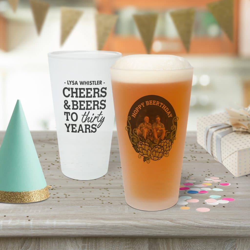 Two frosted pint glasses sitting on a table; they are part of a birthday celebration