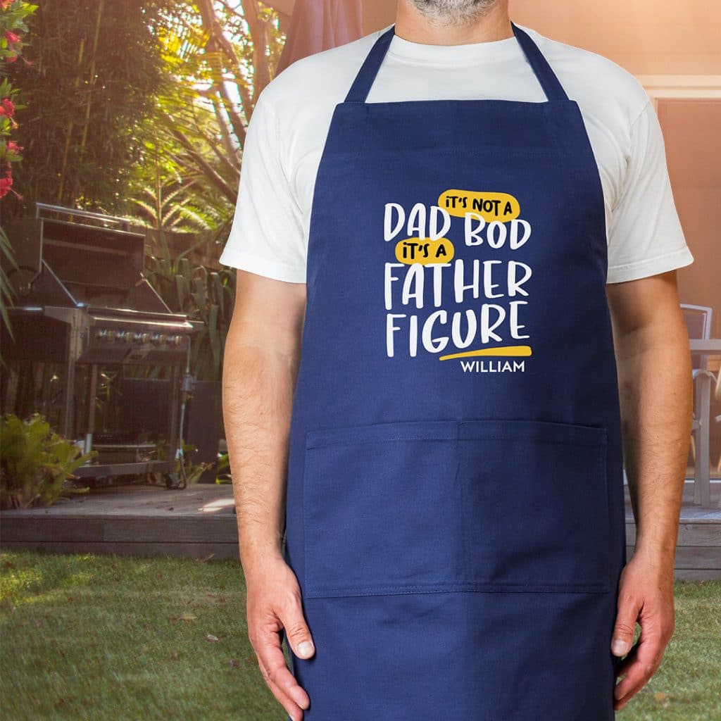 Image of navy blue apron with design reading "It's not a dad bod, it's a father figure" and the name William.