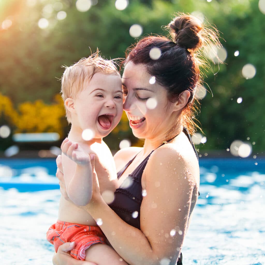 Image of mom holding toddler son in a swimming pool