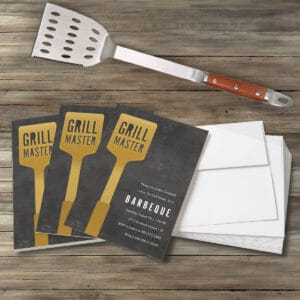 Flat lay image of party invitations featuring Grill Master design