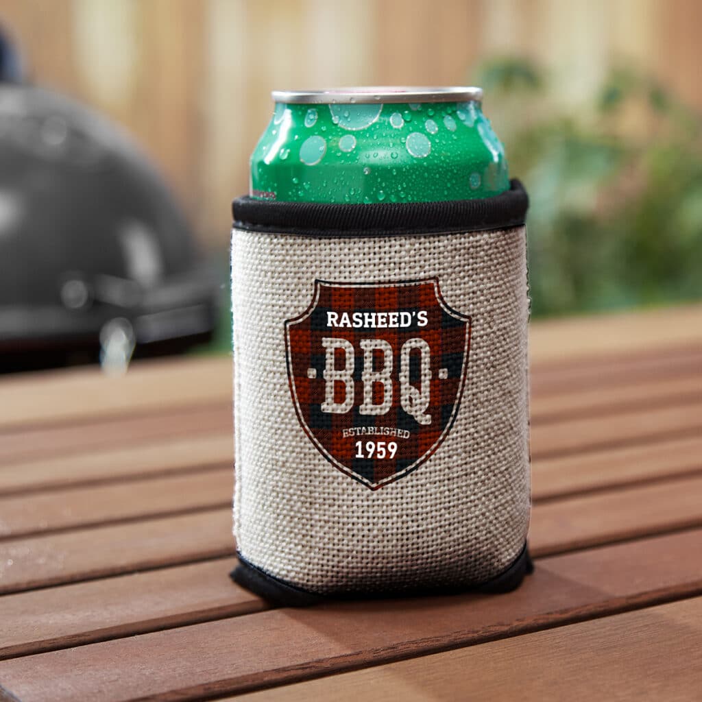 Image of a cloth can cooler around a canned beverage. The design on the cooler reads "Rasheed's BBQ Established 1959"
