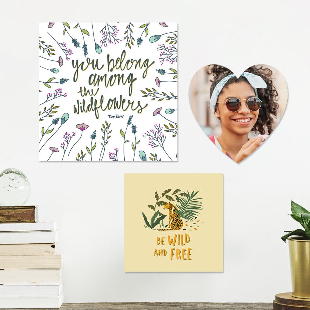 Image of photo tiles hanging on a wall. An entryway table with a houseplant in a vase and a stack of books is in the foreground.