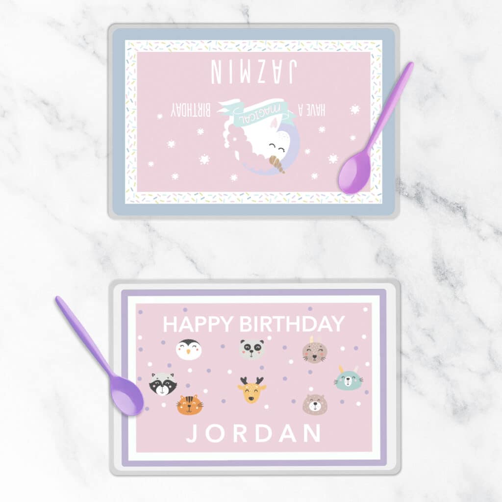 Image of two personalized placemats featuring birthday designs. Next to them are a pair of spoons.