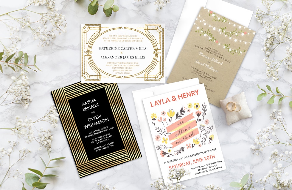 four wedding invites surrounded by baby’s breath flowers