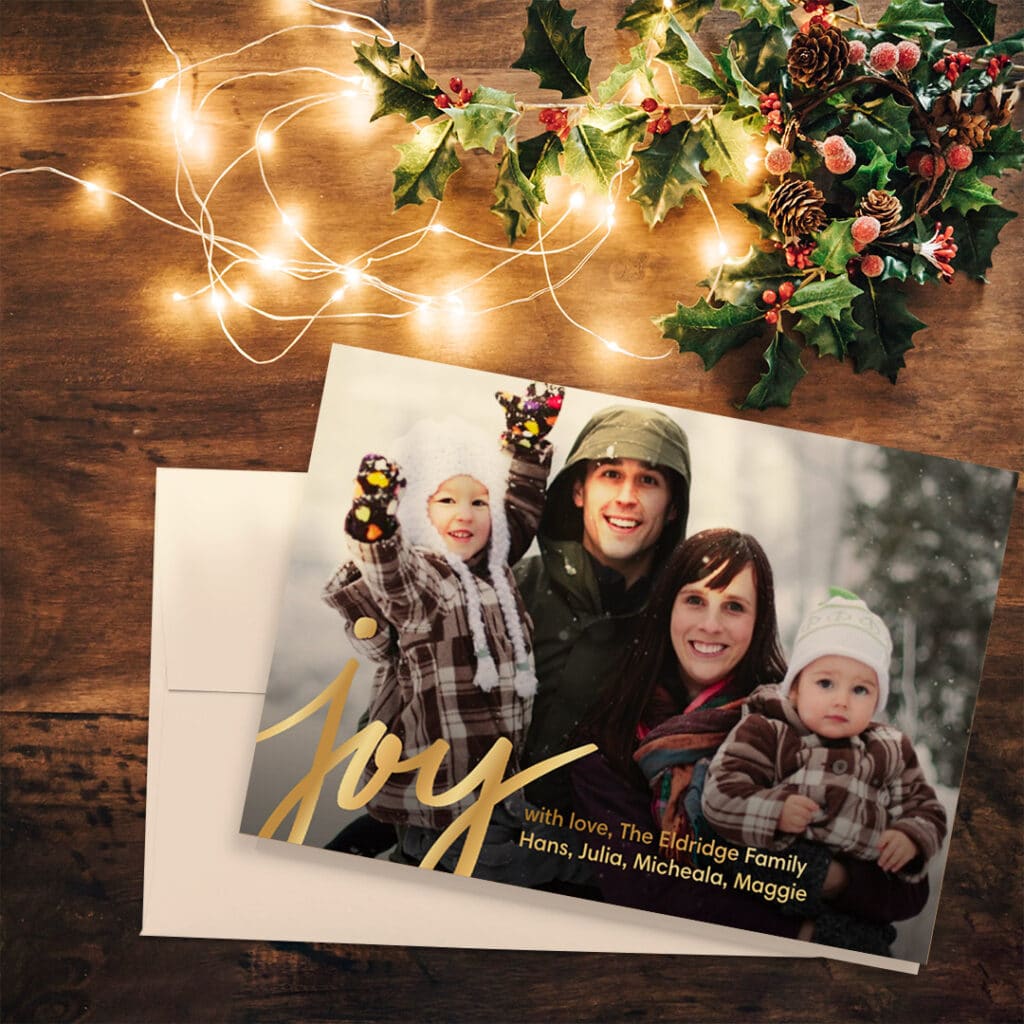 holiday photo card with holly and lit with string lights