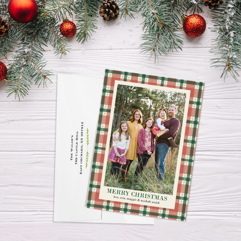 plaid christmas card with custom envelope, below holiday greenery and ornaments