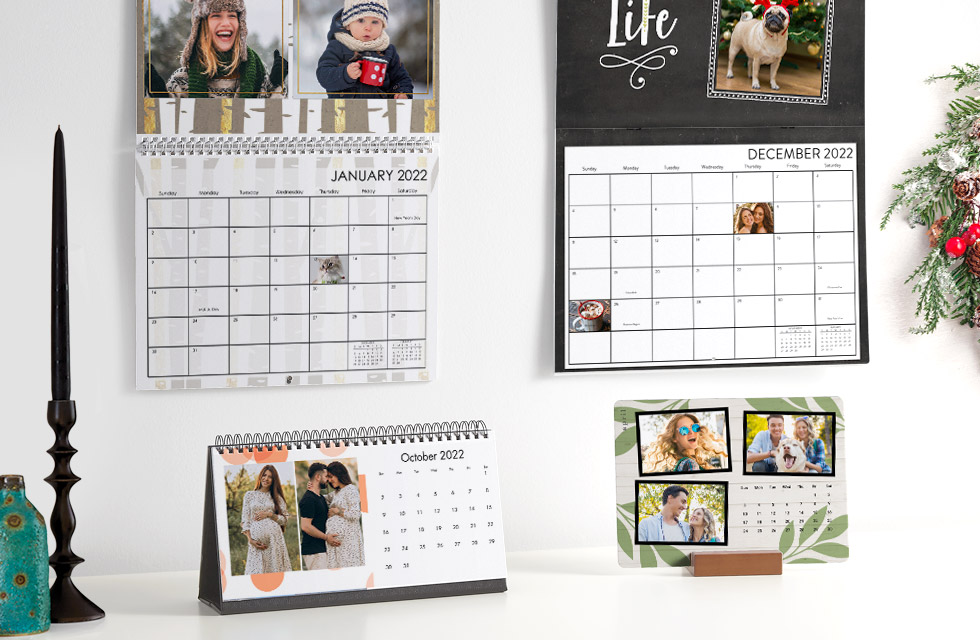 A selection of personalized wall and table calendars displayed on a lovely mantle with candles