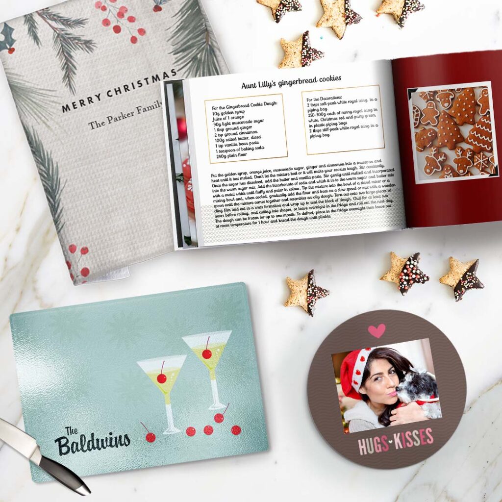 a personalized recipe photo book, a cutting board, tea towel and a coaster placed on a kitchen counter with star cookies on it