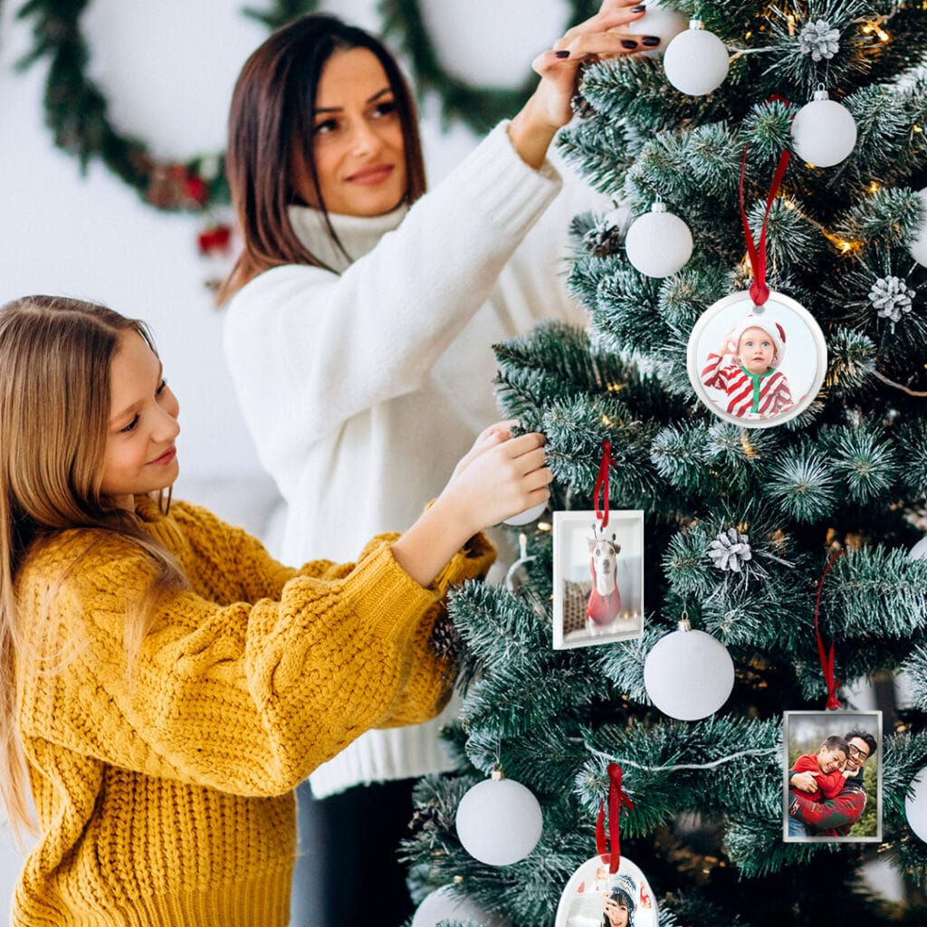Mom and daughter decorating a Christmas tree with Silver Frame Ornaments and Glass Photo Ornaments