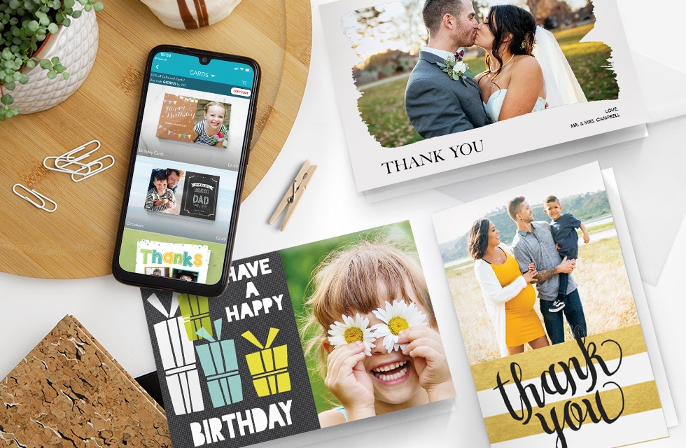 3 colourful greeting cards next to a phone on a desk
